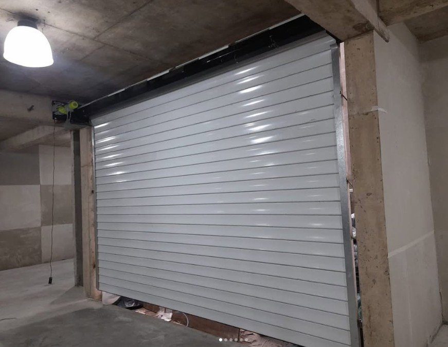 Cortina metálica blanca automatizada en una cochera